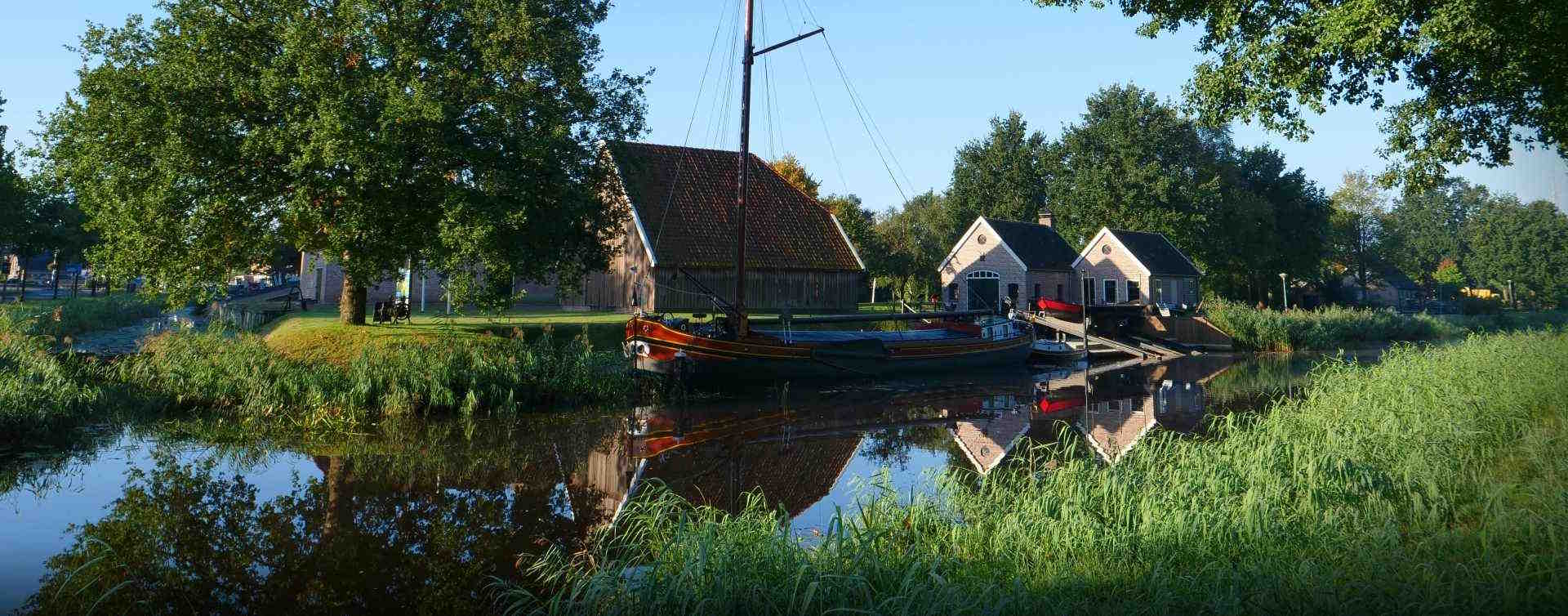 Zeilboot op kanaal in Dedemsvaar, RegioBank in Dedemsvaart